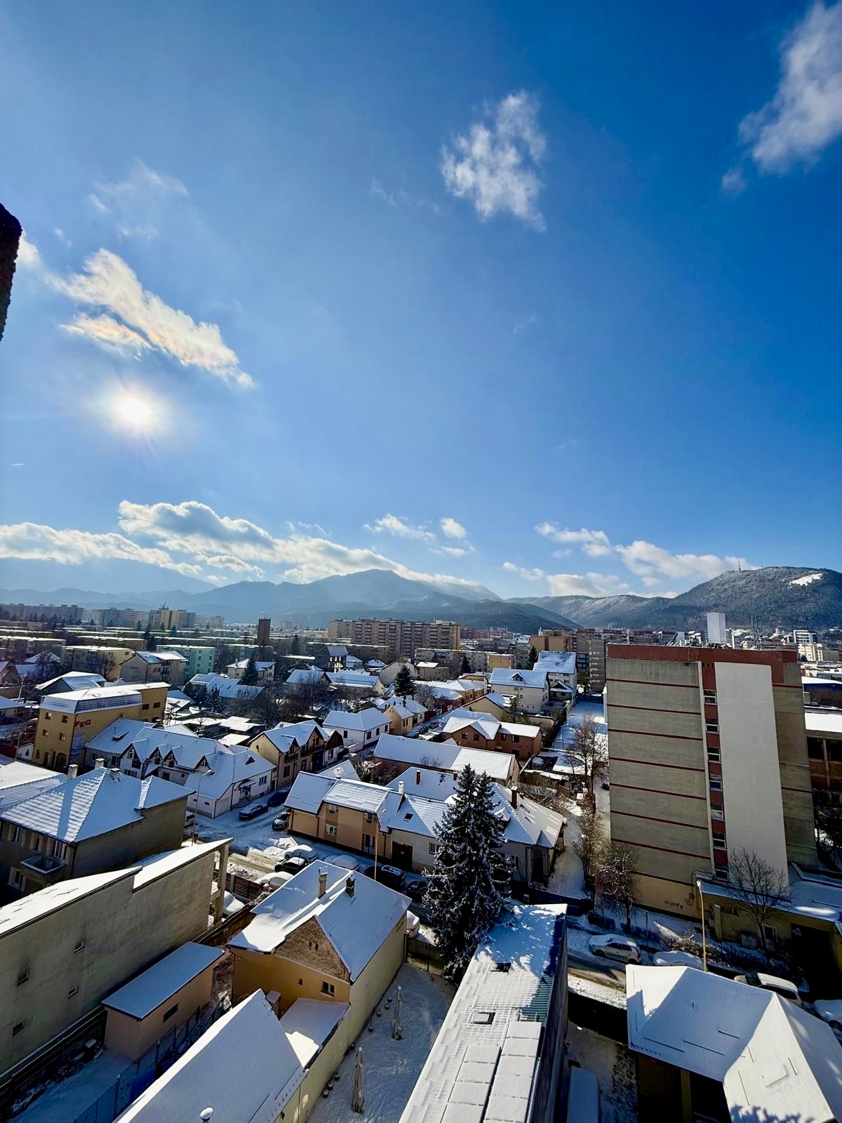 Priveliștea iarna de la fereastra garsonierei, cu munții înzăpeziți